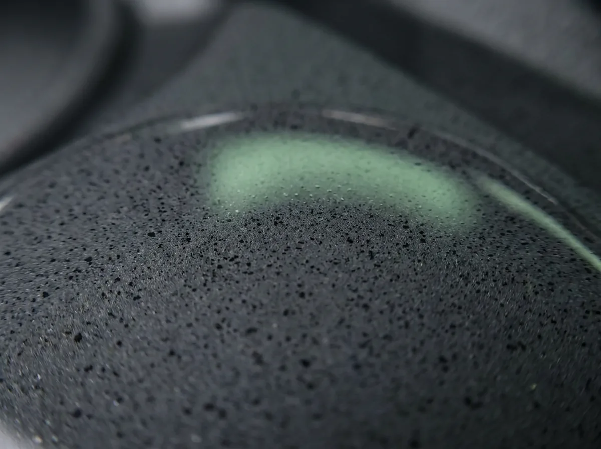Close-up of a dark coated surface with dispersed pigment particles